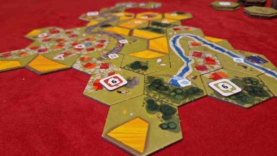 Dorfromantik Board Game review - author photo showing the game tiles laid out on the table with task tokens on them