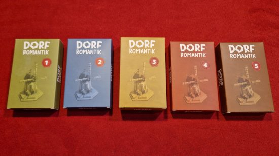 Dorfromantik Board Game review - author photo showing the five included tuckboxes of new game materials unlockable through the campaign