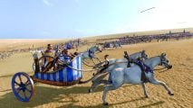Total War Pharaoh review - game screenshot showing Ramesses III riding across the battle in a chariot