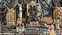 Closeup of Daniel McGirr's first Warhammer 40k Golden Throne Diorama - the Emperor, a skeletal figure in dark robes, connected by many wires to the mechanisms of a strange machine - candles, skulls, purity scrolls, and cherabim surround him