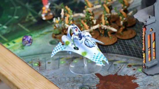 London GT super-major Warhammer 40k tournament - an Eldar Harlequin grav bike, painted white, advances through a ruined city-scape past green and orange wraith constructs
