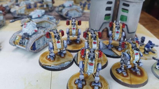 Legions Imperialis review - Aethon heavy sentinels advance through a city, with a Malcador tank in support