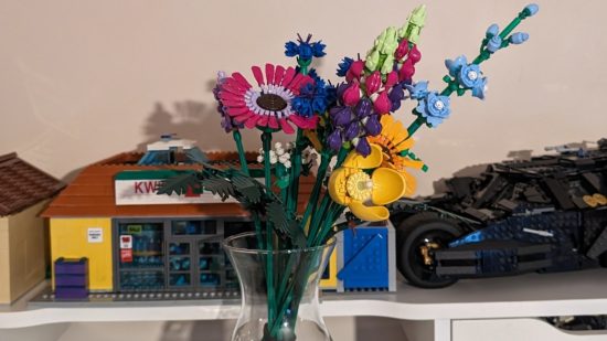 Lego Wildflower Bouquet review image showing the assembled set in a vase in front of the Kwik-E-Mart and Batmobile Lego sets.