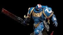 Warhammer 40k Space Marine 2 Titus Weta Workshop statue - Games Workshop photo showing the Titus statue with helmeted head and chainsword, against a black background