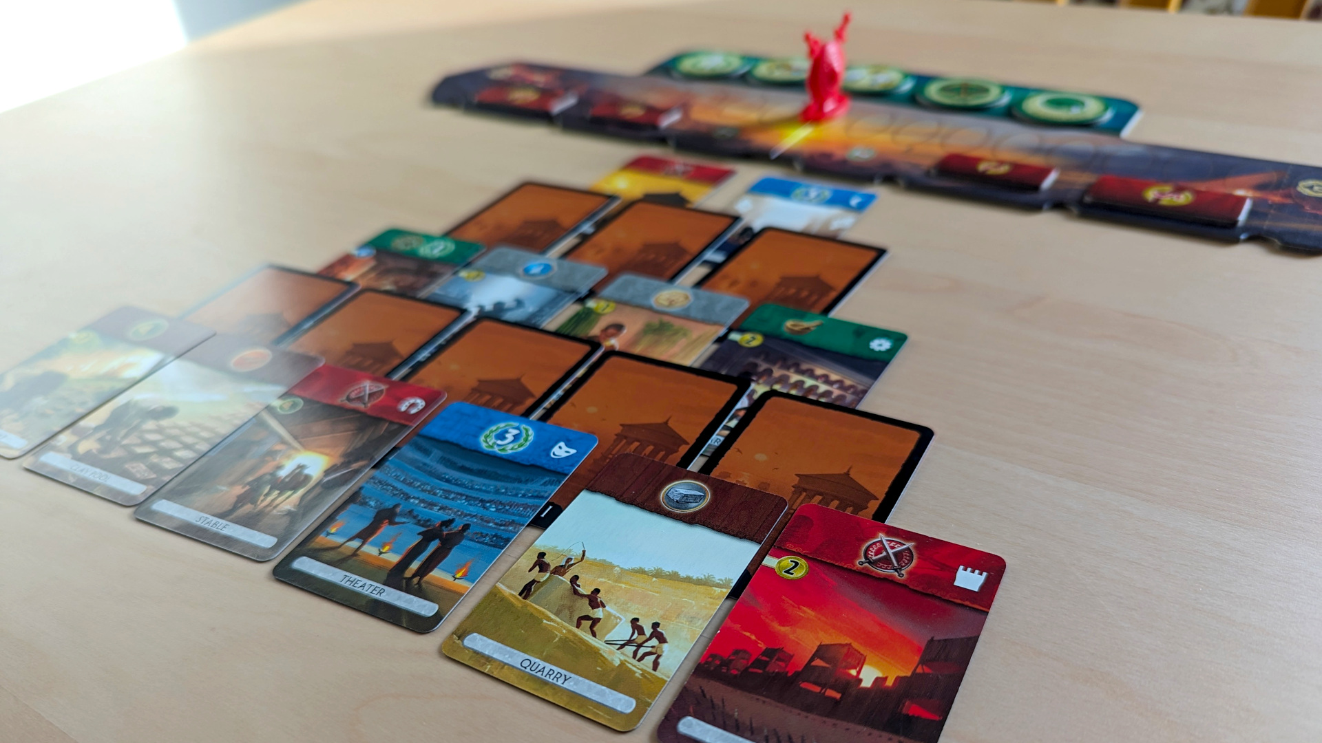 7 Wonders Duel review - author photo showing the game's cards and military victory track laid out on a table