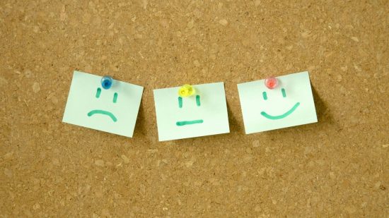 Losing at Warhammer 40k - stock photo showing three post it notes, with sad, neutral, and happy faces drawn on them