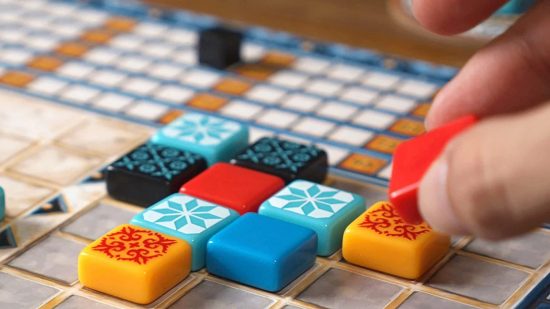 How to play Azul - photo of a hand placing tiles in Azul