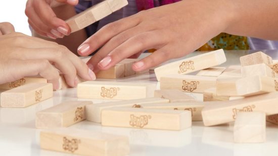 How to play Jenga - Hasbro photo of hands organizing Jenga blocks