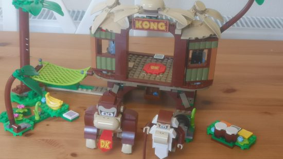 Lego Donkey Kong's Tree House review image showing the completed set with Donkey and Cranky standing in front of it.