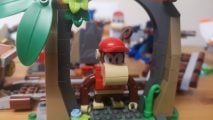 Lego Donkey Kong: Diddy Kong's Mine Cart Ride review image showing Diddy standing in a jungle arch.