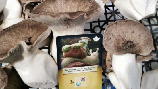 review - Black Pearl mushrooms beside a card depicting a King Oyster riding a snail