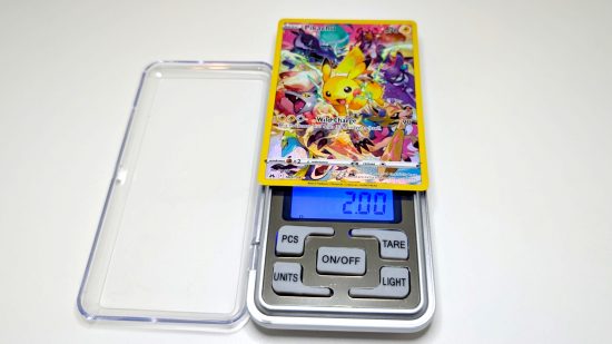 Pokemon card size and weight guide - Wargamer photo showing a full art Pikachu card being weighed
