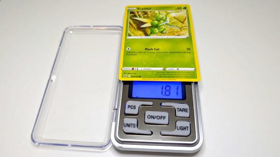Pokemon card size and weight guide - Wargamer photo showing a common Scyther card being weighed
