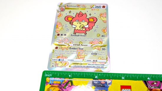 Pokemon card size and weight guide - Wargamer photo showing a full art Simisear card with a lego ruler measuring its width