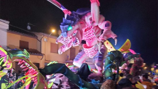 Enormous Warhammer 40k Tyranid carnival float, a huge alien monsterEnormous Warhammer 40k Tyranid carnival float, a huge alien monster, paraded through the streets at nighttime