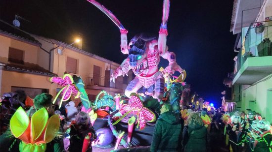 Enormous Warhammer 40k Tyranid carnival float, a huge alien monster, being paraded through the streets at night time