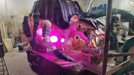 Enormous Warhammer 40k Tyranid carnival float, a huge alien monster, glowing with red lights