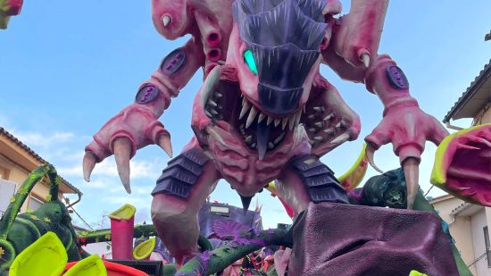 Enormous Warhammer 40k Tyranid carnival float, a huge alien monster, looms over the camera