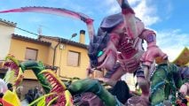 Enormous Warhammer 40k Tyranid carnival float, a huge alien monster, being paraded through the streets at daytime