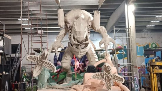 Enormous Warhammer 40k Tyranid carnival float, a huge alien monster, being constructed around a steel frame