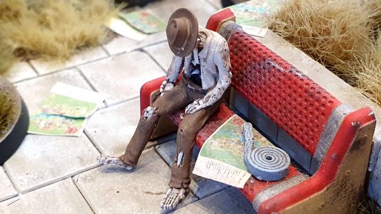 Fallout Factions - an envrionmental storytelling skeleton slumped in a chair next to a map of a theme park and a reel of tickets