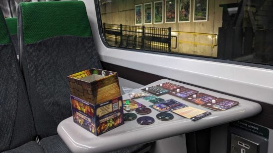 Gloomhaven Buttons & Bugs board game on a train travel table
