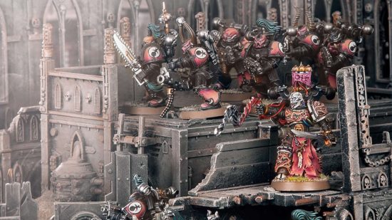 Warhammer 40k Chaos Space Marines - Lucius the Eternal, a pale-faced grinning villain with a whip, leads a squad of pink and black armored Chaos Space Marines through the ruins of an Imperial world
