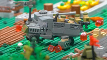 Lego Bolt Action truck on a battlefield - a grey WW2 German truck on a battlefield strewn with Lego debris