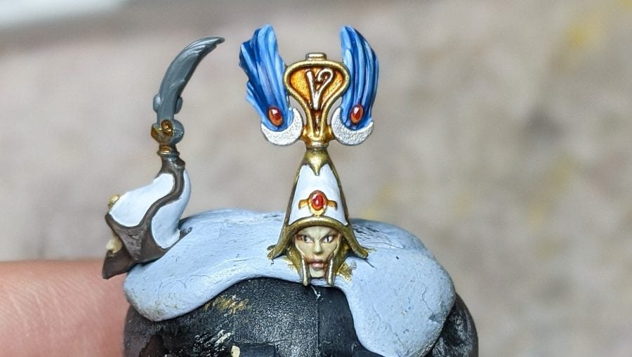 Painting miniatures guide fine detailing as shown by a Lumineth realm-lord's face
