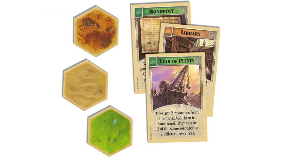 How to play Catan - Official Catan marketing photo showing three board hexes and three Development Cards