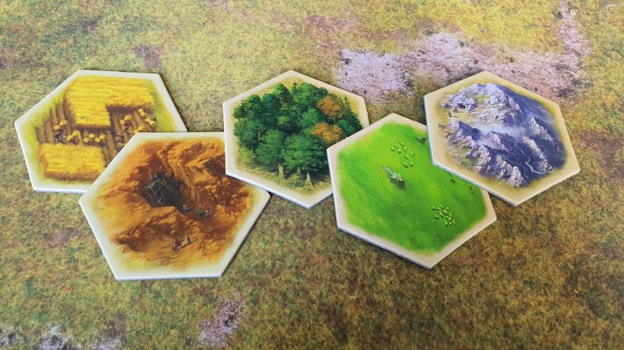 How to play Catan - Wargamer photo of Catan standard edition board game components, showing resource tiles for the five resources: Wheat, Clay, Wood, Sheep, and Ore