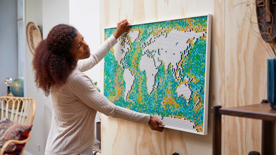 Biggest Lego sets a woman hanging the art world map from a wall