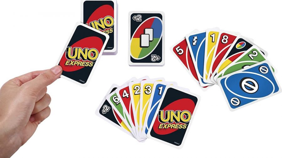 Uno rules - a hand holding a single uno card, with multicoloured uno cards spread out beside it
