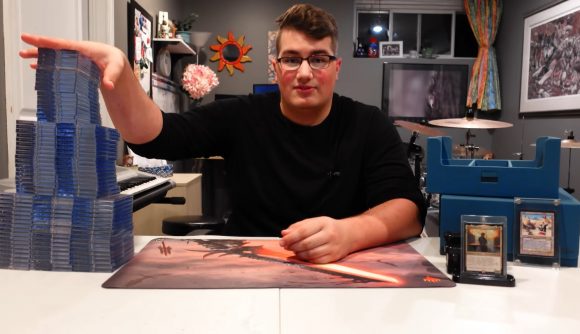 Magic the Gathering Commander deck giant: Youtuber Sam Huggins placing one hand on top of a towering EDH deck.