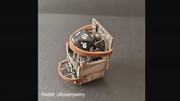 DnD dice DIY torture device - a custom-made torture chair made of card, leather straps, and thumbtacks. A d20 is strapped into the chair and forced to sit on the thumbtacks.